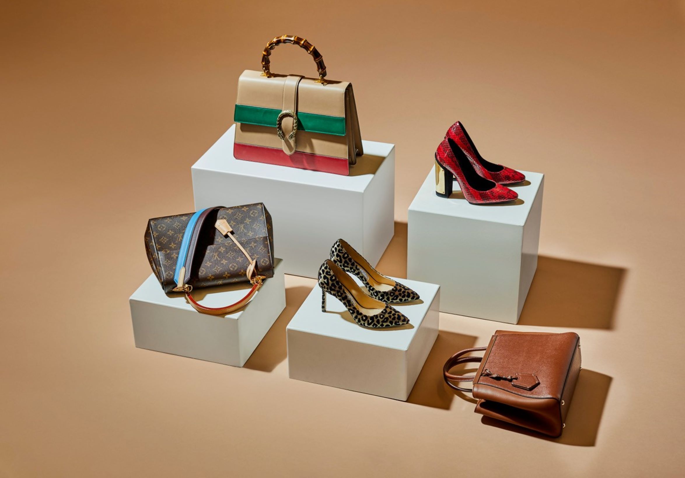 Sacs à main, chaussures et accessoires de luxe de seconde main exposés sur des socles